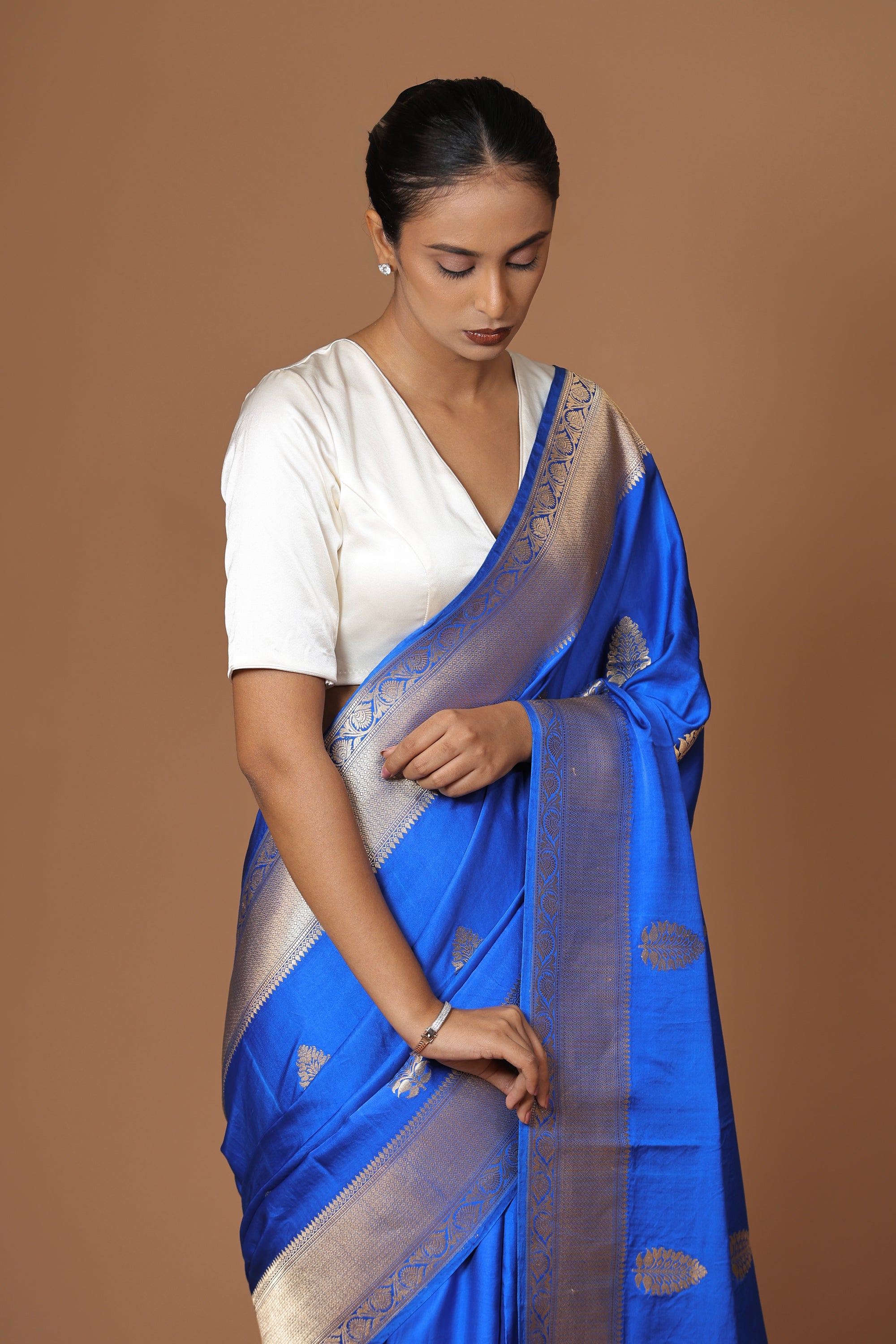 Banarasi handwoven blue satin silk sari with a lustrous, regal finish.