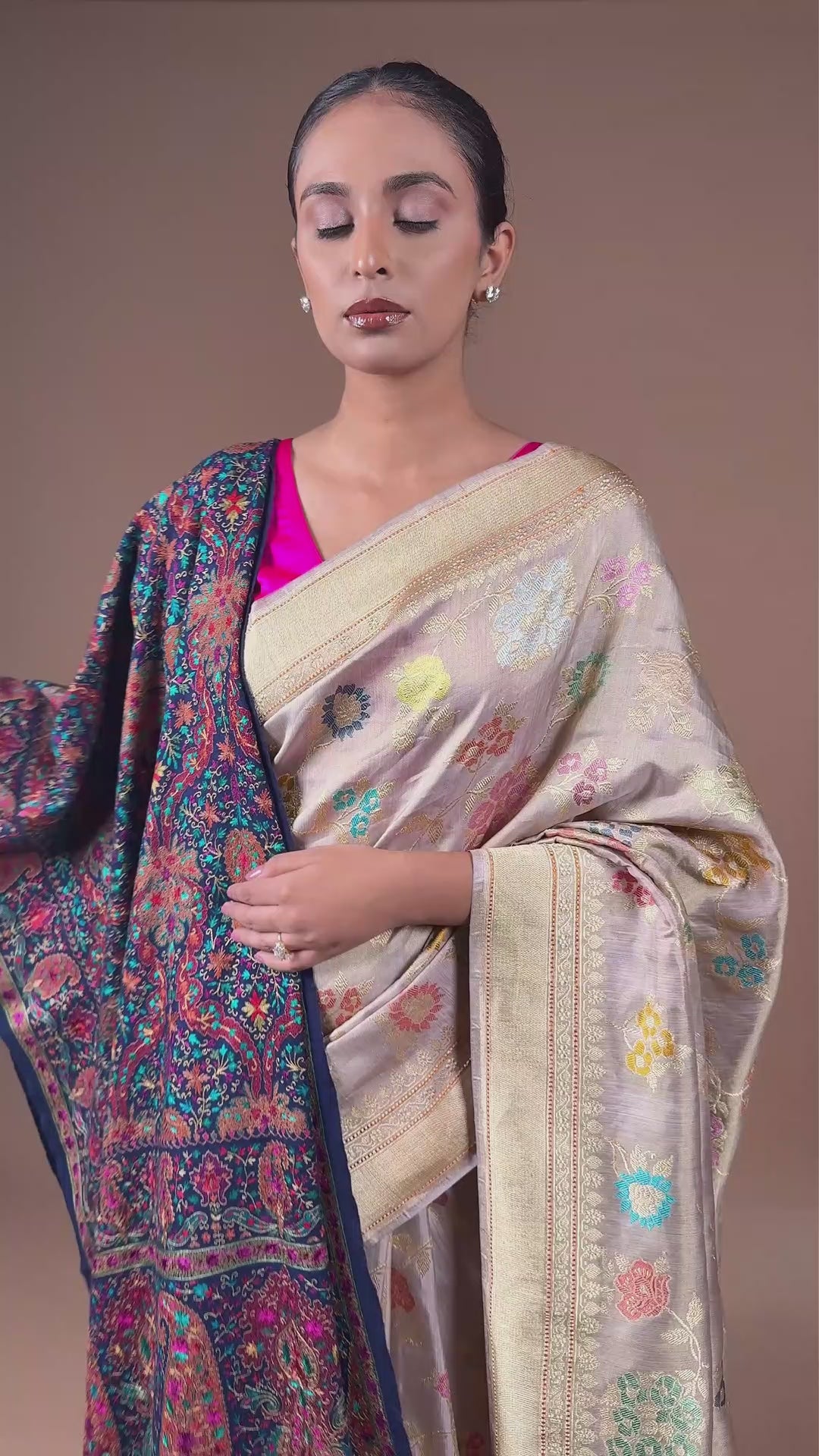 Handwoven Banarasi tissue silk sari in soft silver, featuring vibrant meenakari floral motifs and a golden border.